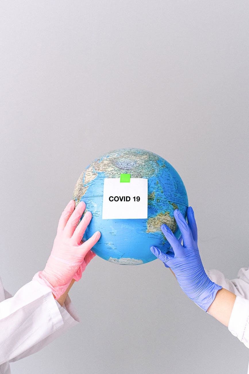 hands with latex gloves holding a globe
